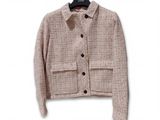 the jacket is hanging on a hanger on a white wall
