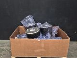 une boîte en carton remplie d'objets bleus posée sur un sol en béton