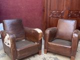 deux fauteuils en cuir marron placés l'un à côté de l'autre dans une pièce