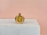 a gold coin ring sitting on top of a marble block