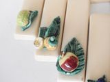 four ceramic figurines of fruits and vegetables on display