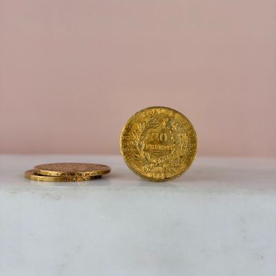 a gold coin sitting on top of a white counter next to a pink wall