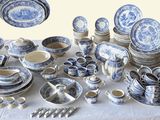 many blue and white plates and bowls on a table