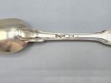 an antique silver spoon with a spoon handle on a white surface