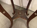 a small table with a marble top on a tile floor