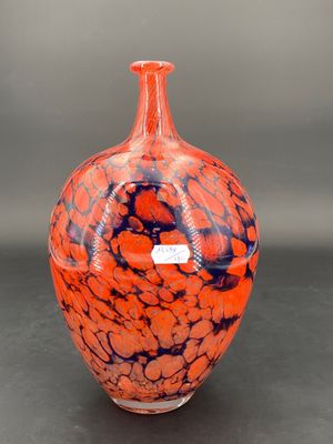 un vase orange et bleu posé sur une table noire