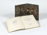 un livre ouvert posé sur une table blanche à côté d'un livre