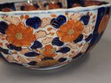 a blue and orange bowl with orange flowers on it