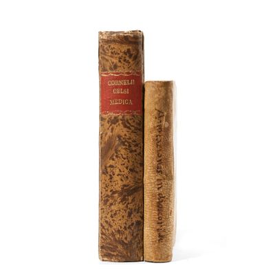 two old books sitting on top of each other on a white surface