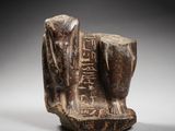an egyptian carved statue of a man and a woman