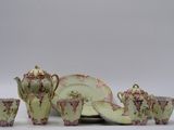 a green and pink tea set with cups and saucers