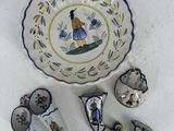 un bol, une cuillère et des tasses posés sur une surface blanche