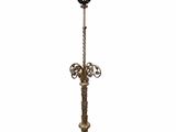 un lampadaire ancien en laiton surmonté d'un abat-jour en verre