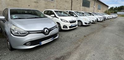 de nombreuses voitures garées en rangée devant un immeuble