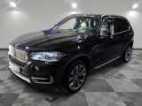 the black bmw suv is parked on a checkered tile floor