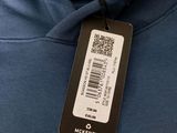 a close up of a blue sweatshirt with a tag on it