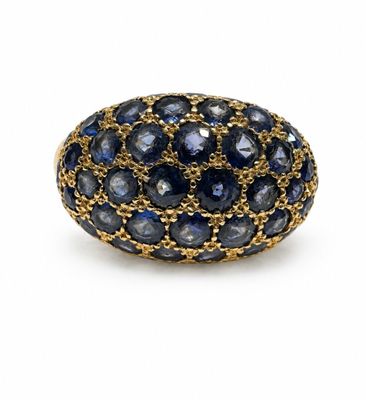 a close up of a ring with blue sapphires on a white background