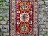 un tapis rouge accroché à un mur de briques, à côté d'un mur de briques