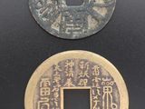 deux pièces chinoises posées l'une à côté de l'autre sur une surface noire