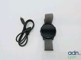 une montre connectée et un chargeur posés sur la table