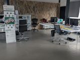 une salle où se trouvent de nombreux bureaux et chaises