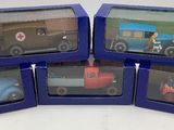 six petites voitures miniatures se trouvent dans une boîte bleue posée sur une surface blanche