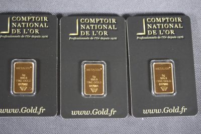 three gold bars are sitting next to each other on a table