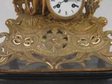 a gold clock sitting on top of a black table