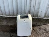 un petit climatiseur blanc installé à l'extérieur d'un immeuble