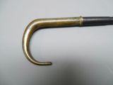 an old brass handle with a black handle on a white surface