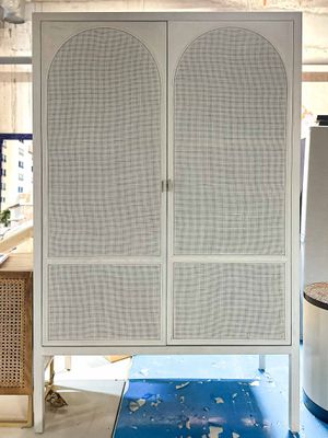an image of a white cabinet with wicker doors