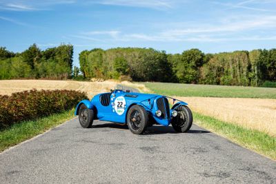 a blue car that is driving down the road