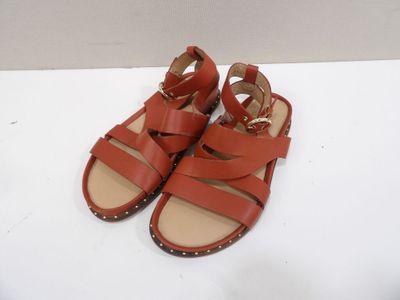 a close up of a pair of red sandals on a white surface