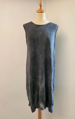 une robe posée sur un mannequin devant un mur blanc