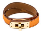 the bracelet is made of brown leather and has a gold clasp