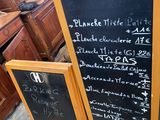 a blackboard with a menu written on it in front of some wooden cabinets