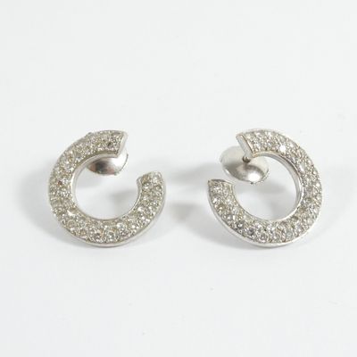 une paire de boucles d'oreilles créoles en diamant sur fond blanc