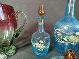 many different colored glass vases sitting on a table