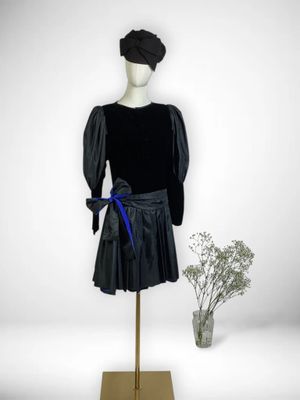 mannequin vêtu d'une robe noire ornée d'un ruban bleu et d'un chapeau