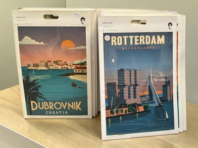 deux cartons remplis d'affiches posés sur une table dans une pièce