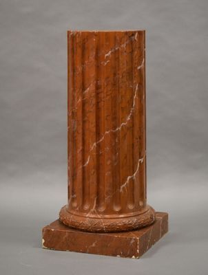 a close up of a red marble column on a gray background