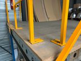 two yellow metal posts on the top of a pallet