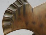 une sculpture en bronze représentant un oiseau perché sur une chaise