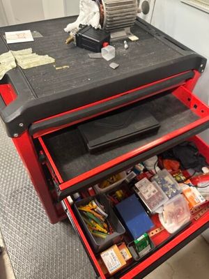 un établi rouge avec deux tiroirs remplis de matériel