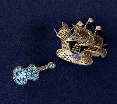 two brooches that are sitting on a blue surface