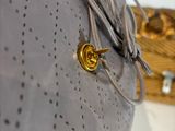 a gray purse with a gold button on it