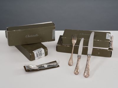une boîte d'argenterie posée sur une table, à côté d'un couteau et d'une fourchette
