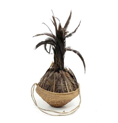 a basket with a plant inside of it on a white surface