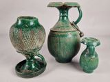 three green vases sitting next to each other on a table