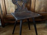 a wooden chair sitting on a wooden floor in front of a wooden cabinet